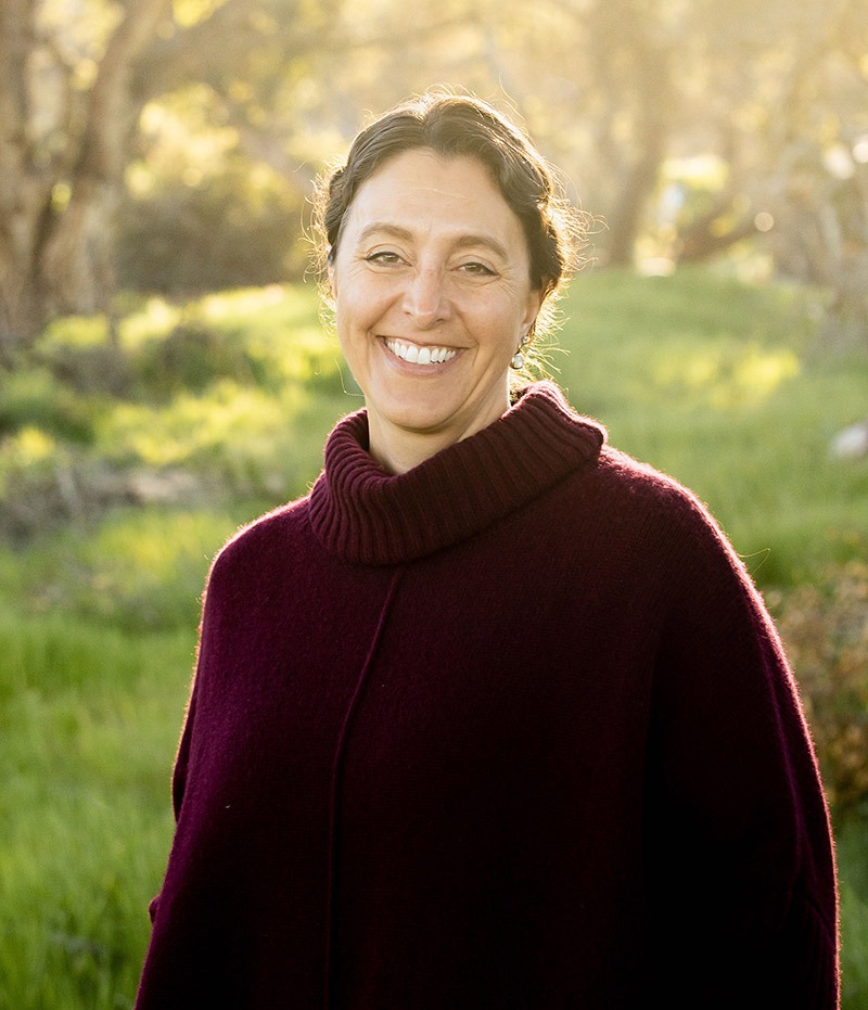 Headshot photo of associate director, Chantel Touryan-Schaefer standing in front of trees.