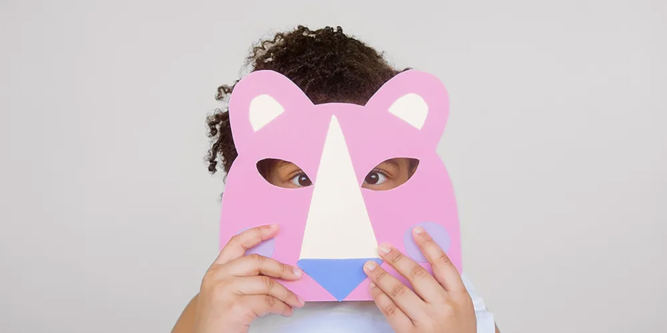 Student hiding behind a colorful animal mask