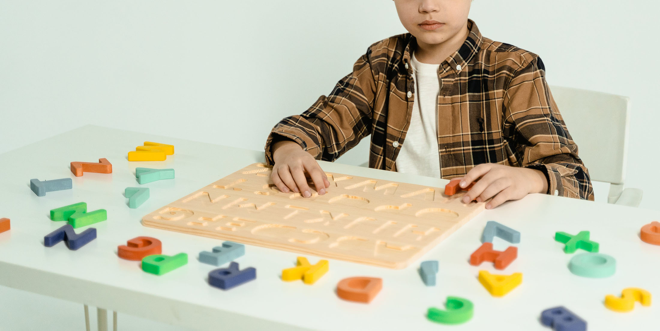 Student working with letter tiles on a puzzle