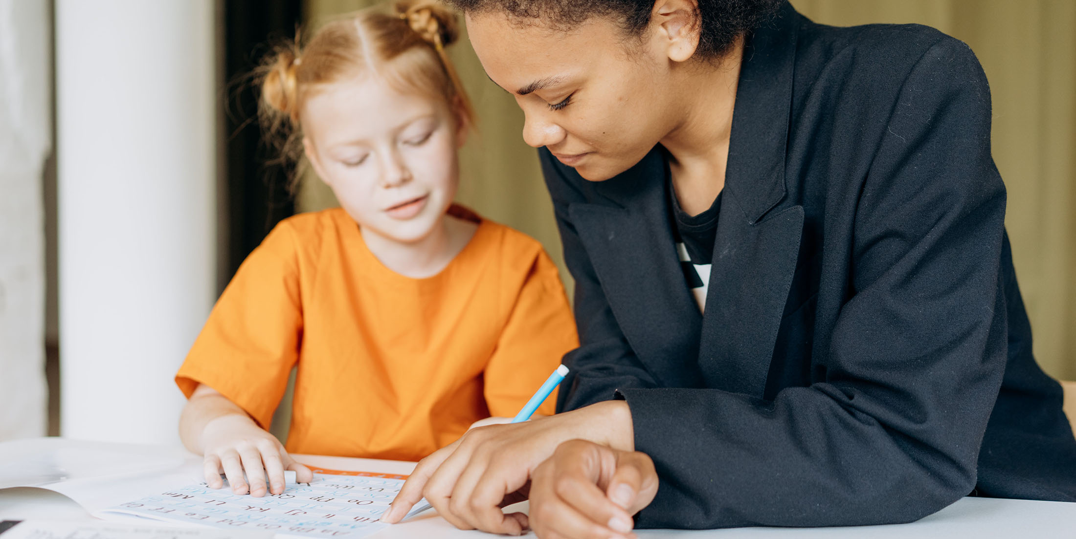 Teacher and student working through a phonics book