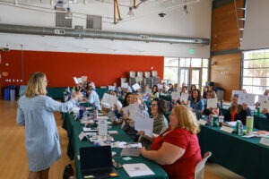 Group of educators in a training holding up whiteboards with letters of alphabet on them. 