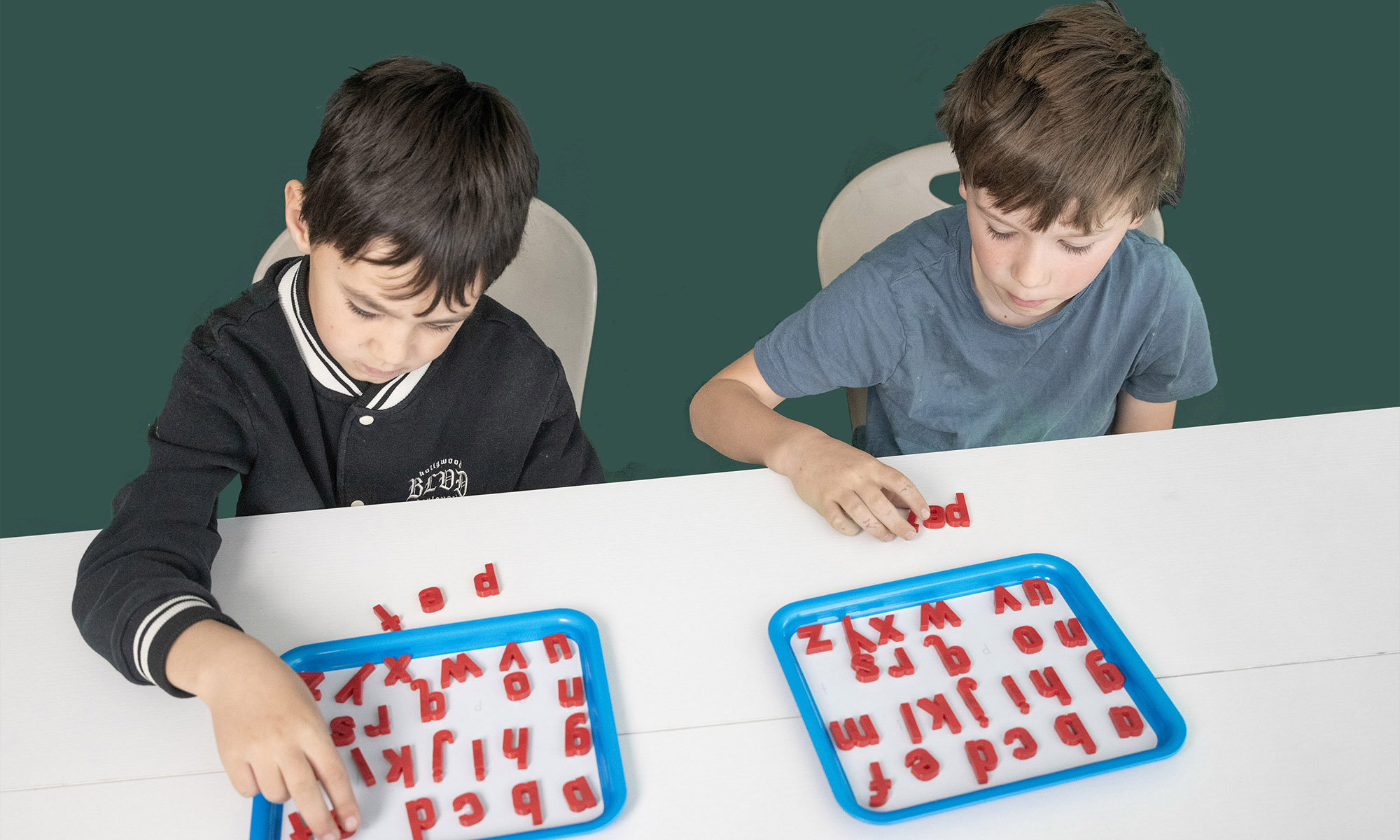 Students working with letters on trays